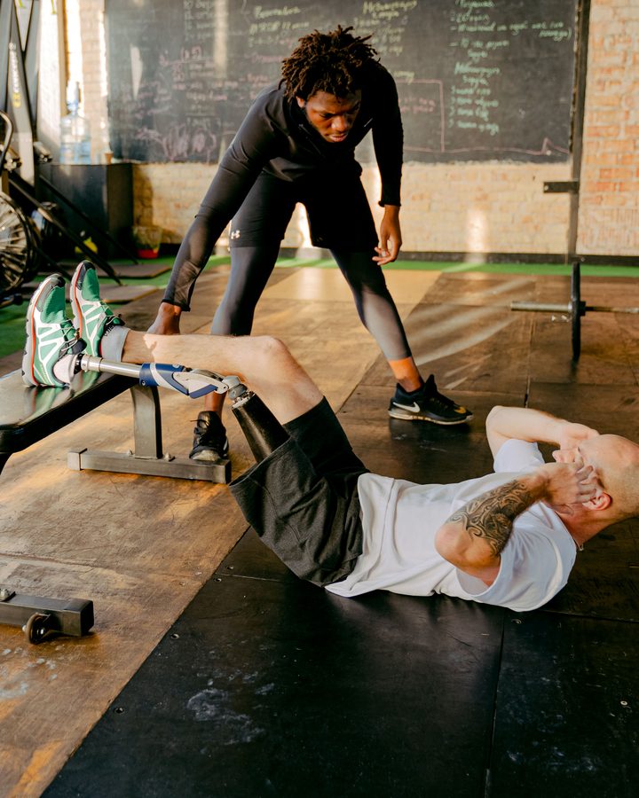 Coach assisting a client through a floor exercise